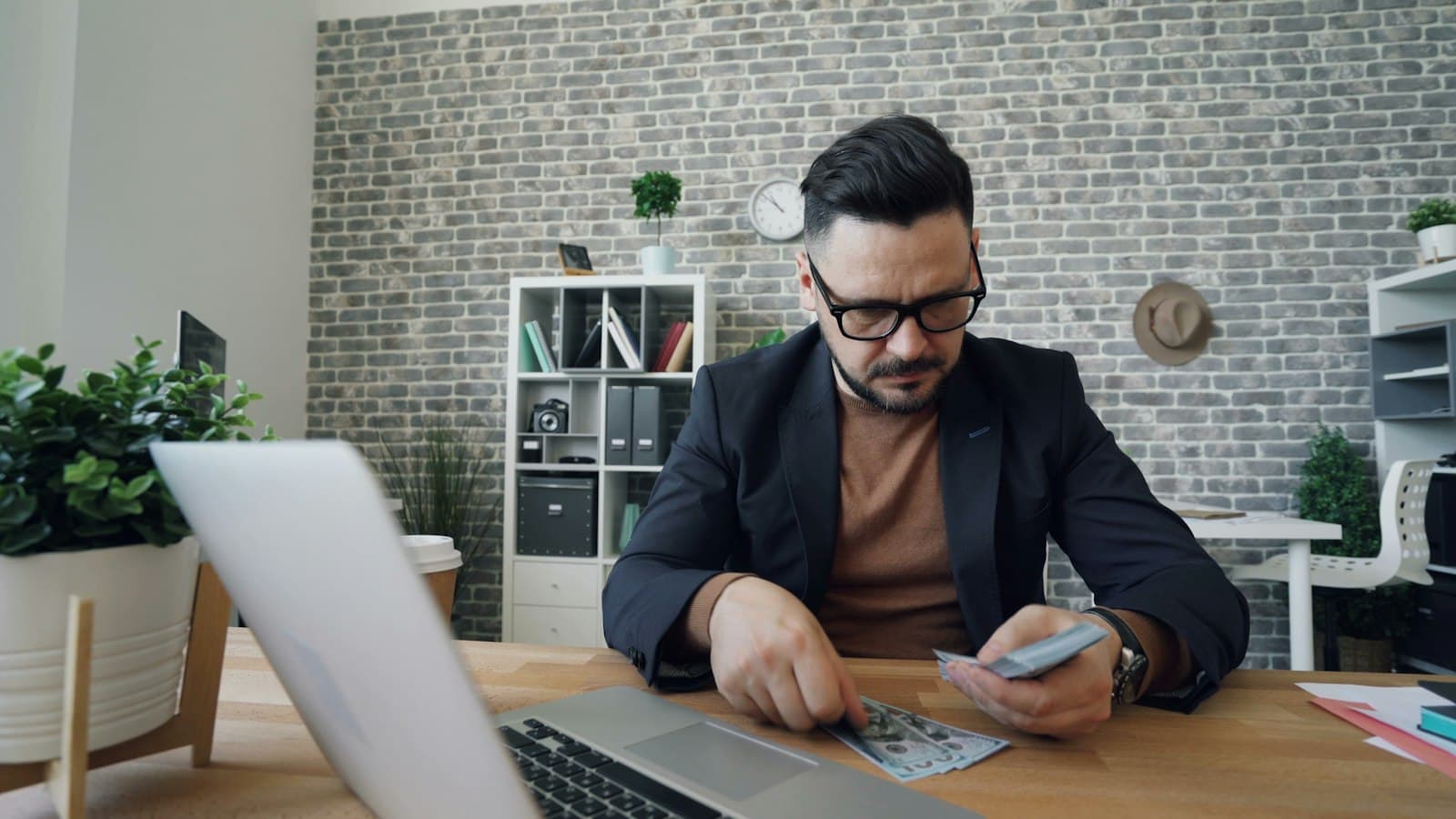 Vlasnik male firme za laptopom pregleda račune